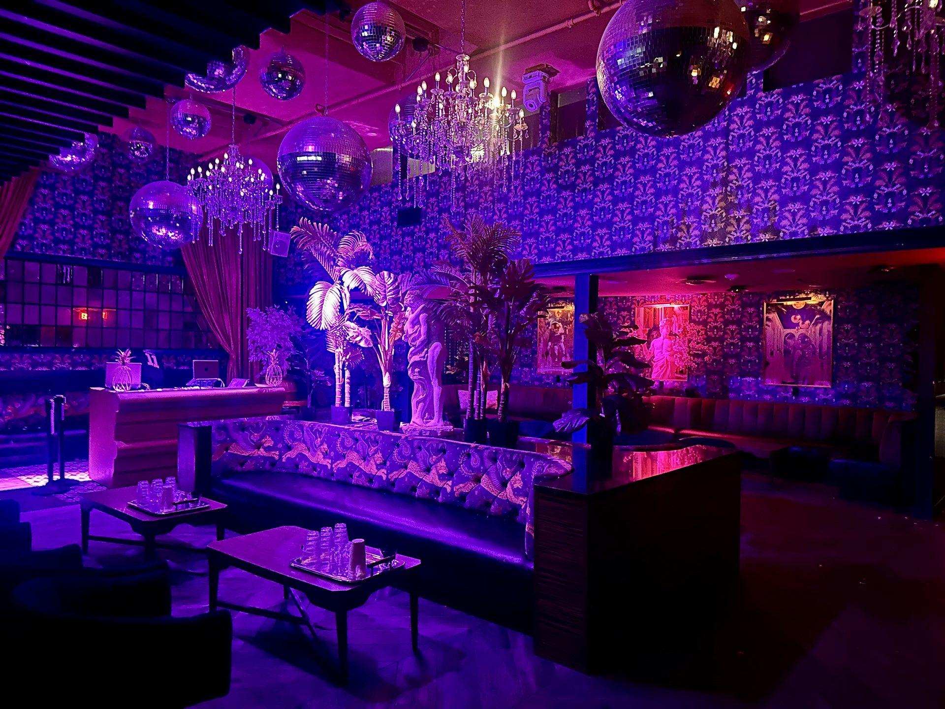 The Friends Only lounge under purple light, disco balls and velvet booths