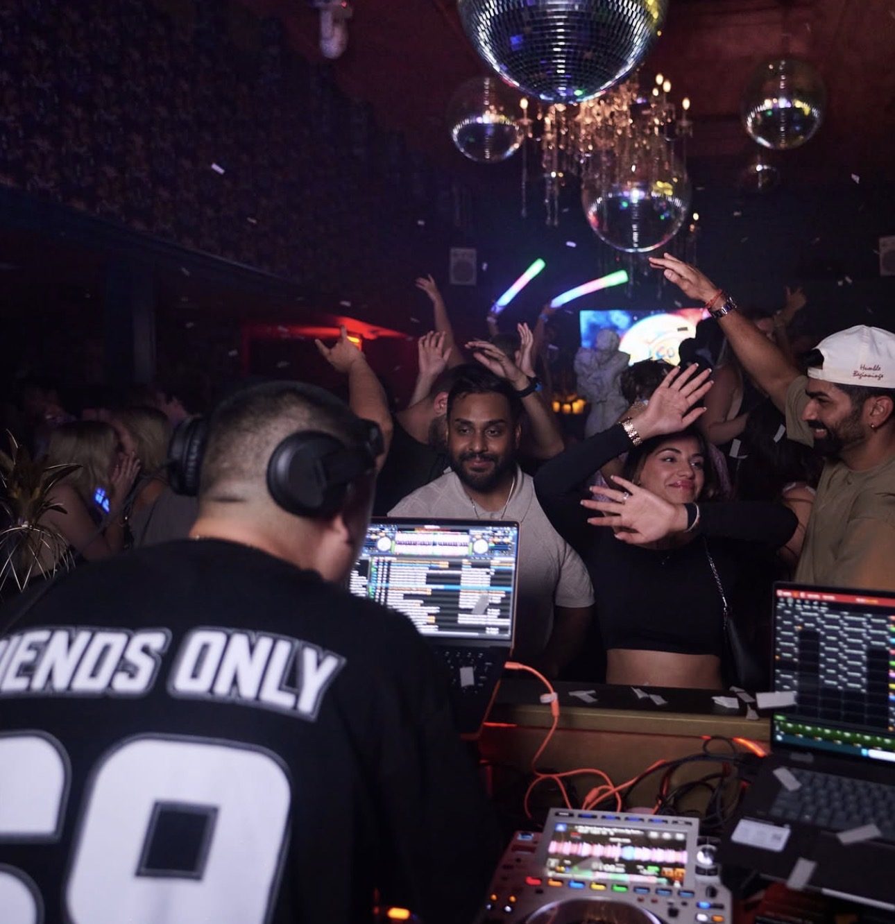 The DJ working the Friends Only floor, crowd with hands raised